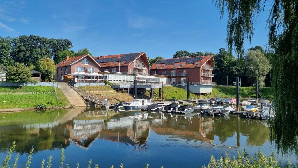 a group of boats docked in a river next to houses at Hotel Restaurant Bootshaus in Achim