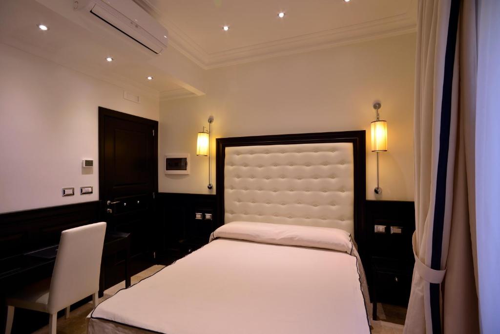 ein Schlafzimmer mit einem Bett und einem Stuhl darin in der Unterkunft Vaticano Royal Suite Guest House in Rom