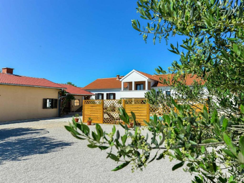 a house with a fence in front of a driveway at Marinic Comfortable holiday residence in Zadar