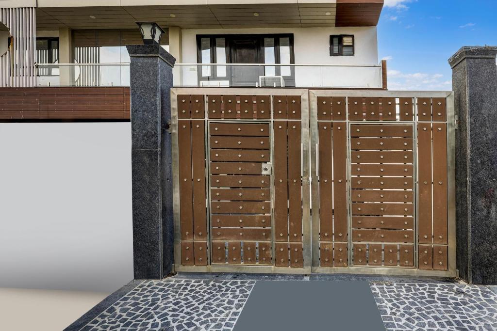 a wooden gate in front of a house at Townhouse Mayfield Garden Nearby Golf course road in Gurgaon