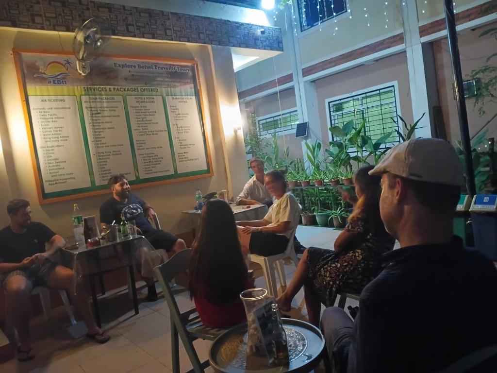 a group of people sitting at tables in a restaurant at Andresas Homestay in Loboc