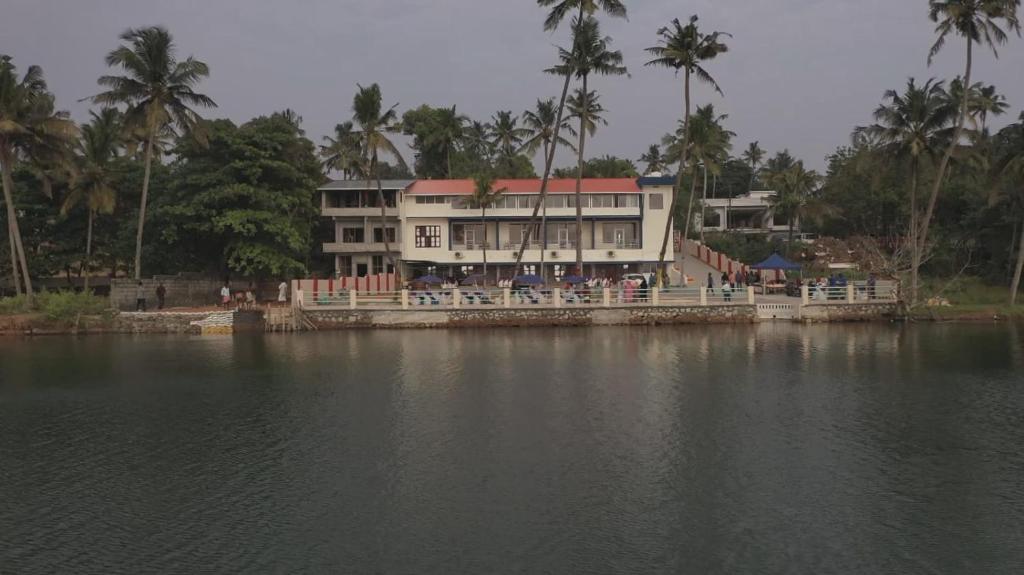 a house on the shore of a body of water at Lake Star Beach Resort in Kappil