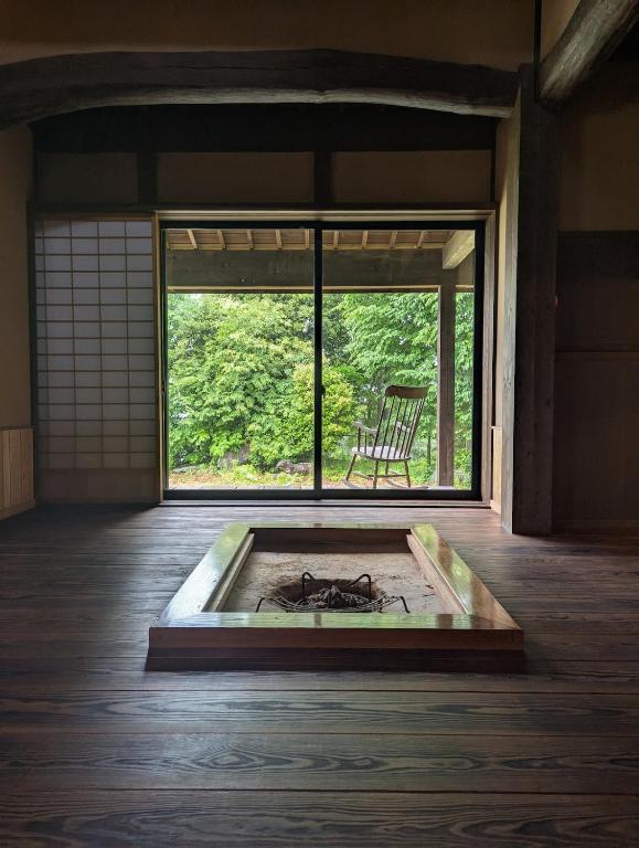 a room with a large window with a chair in it at Yamanoto in Toyooka