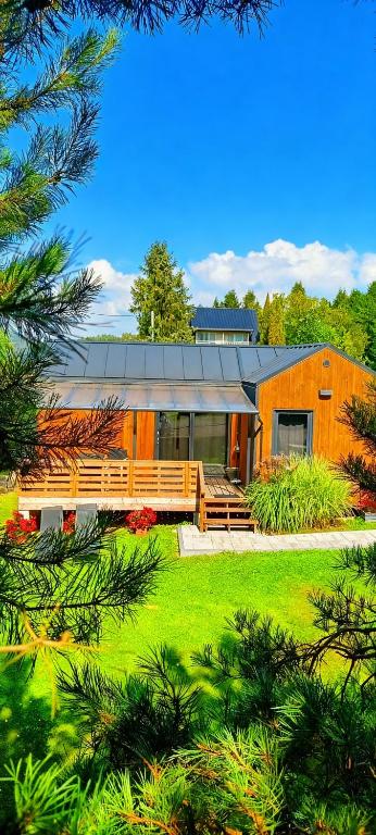 a house with a solarium on top of a yard at Domki u Łosia Bieszczady & Sauna in Polańczyk