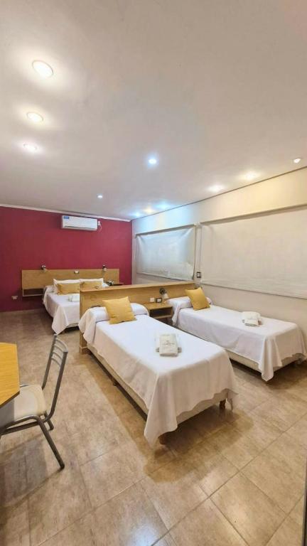 a hospital room with three beds and a chair at Hotel La Giralda CAZ in Vera