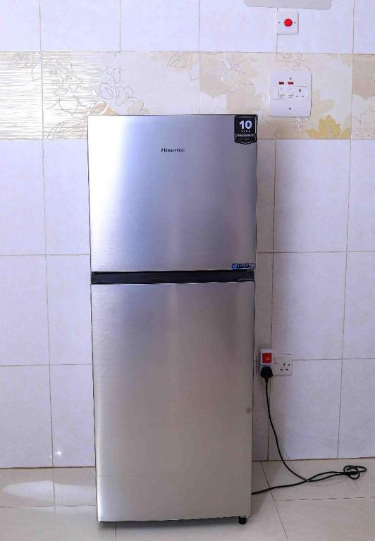 a refrigerator is plugged into a wall in a kitchen at Elite properties in Kampala