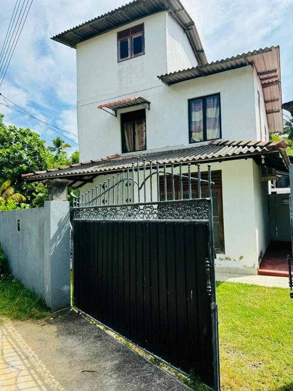 a white house with a black gate in front of it at Matara Villa in Matara