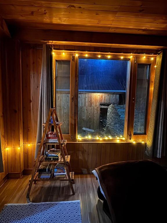 a ladder in a room with a window with lights at The Quiet Corner in Gushaini