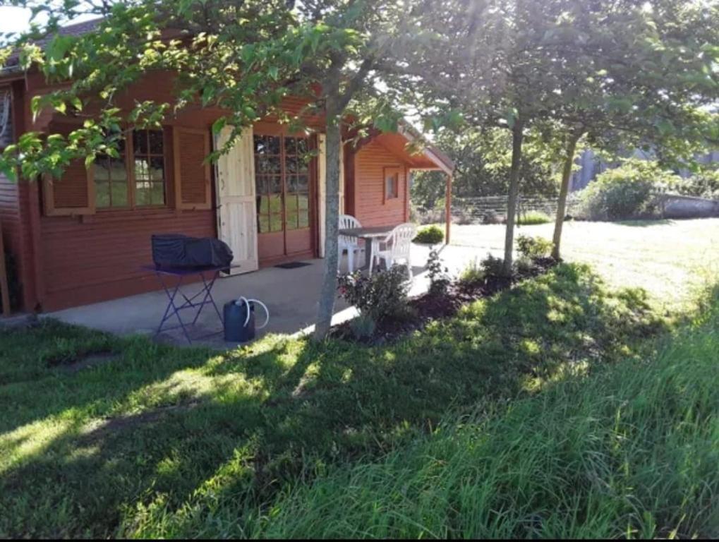 a small house with a porch and a yard at Le Chalet in Les Costes-Gozon