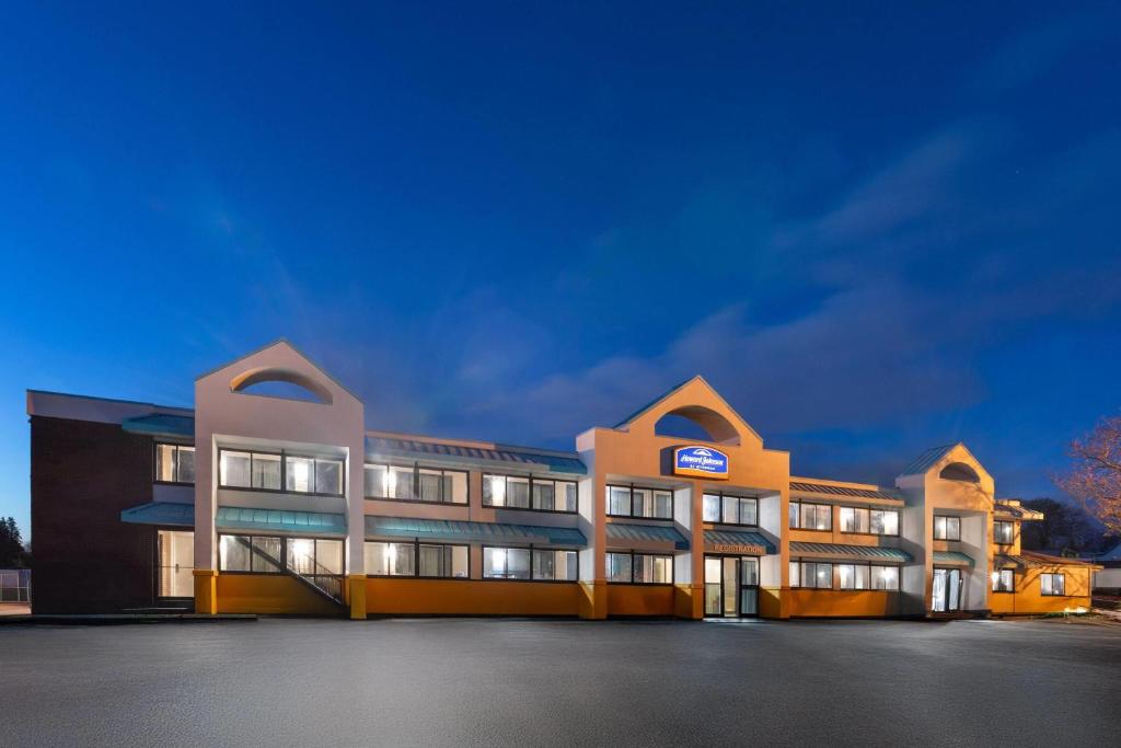 a large building with lights on in a parking lot at Howard Johnson by Wyndham Malden Boston Area in Malden