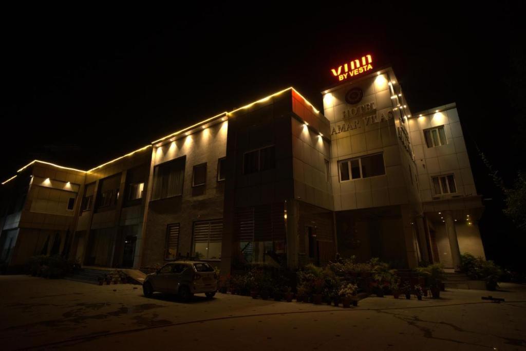 a building with a neon sign on it at night at Amarvilas Hotel & Resort in Bharatpur