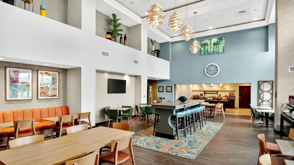 a dining room with tables and chairs in a restaurant at Hampton Inn & Suites Chippewa Falls in Chippewa Falls