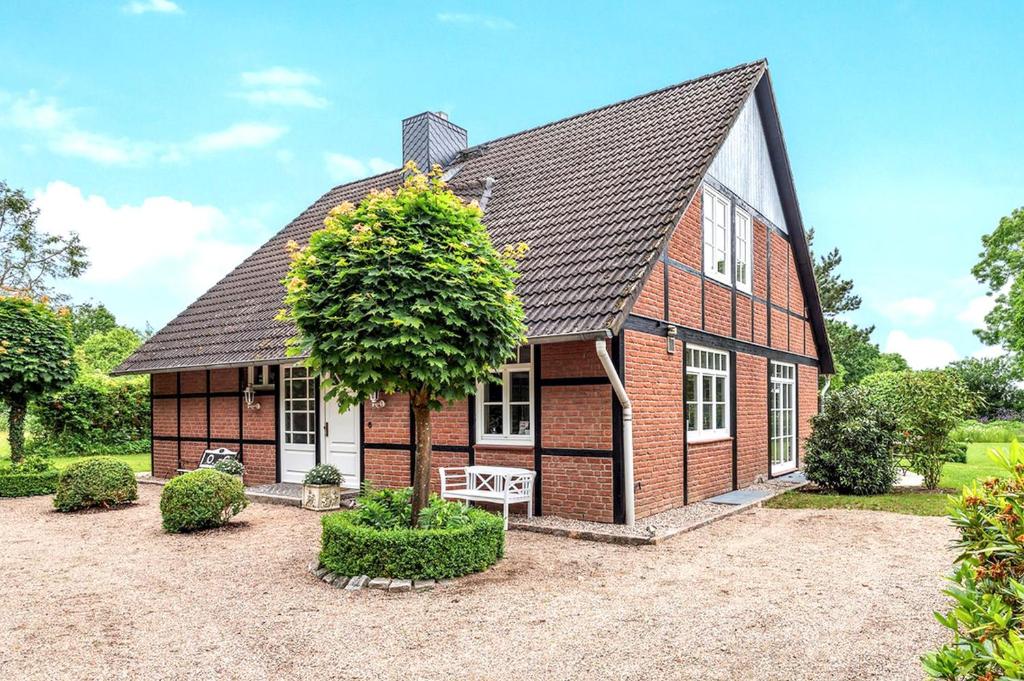 a red brick house with a black roof at Landhaus Köhn - Ostholstein in Giekau