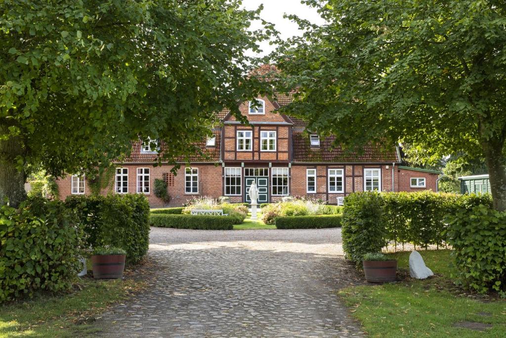 a large red brick building with a pathway in front at Pächterhaus - Ostholstein in Manhagen