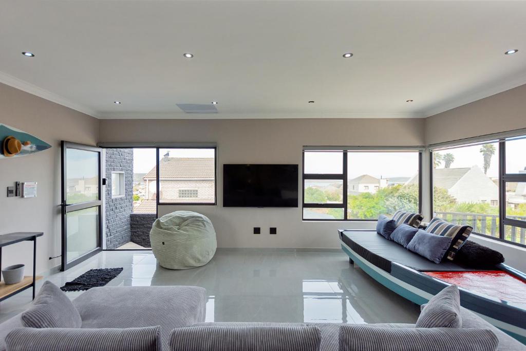 a living room with a couch and a flat screen tv at Grey Luxury Accommodation Langebaan in Langebaan