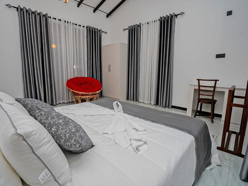 a bedroom with a large white bed with pillows at Ceylon Vista in Galle