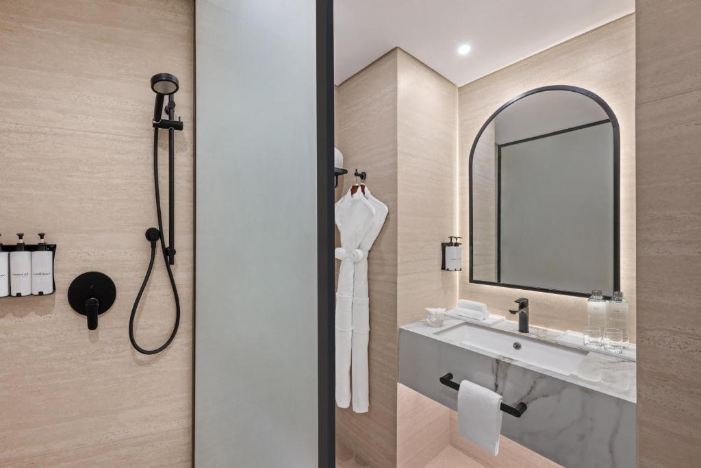 a bathroom with a sink and a mirror at Oaks Ibn Battuta Gate Dubai in Dubai