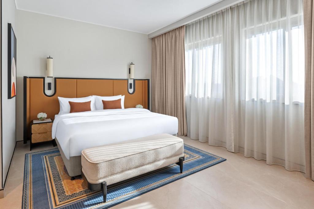 a bedroom with a large bed and a large window at Oaks Ibn Battuta Gate Dubai in Dubai