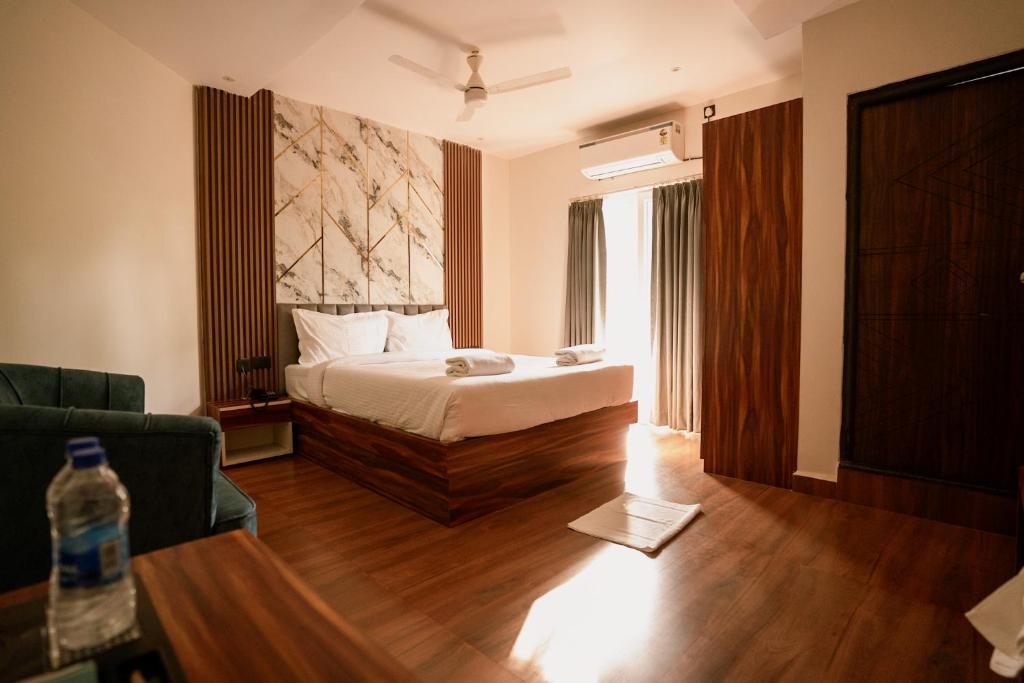 a bedroom with a bed and a living room with a couch at Lume Stayz in Siolim