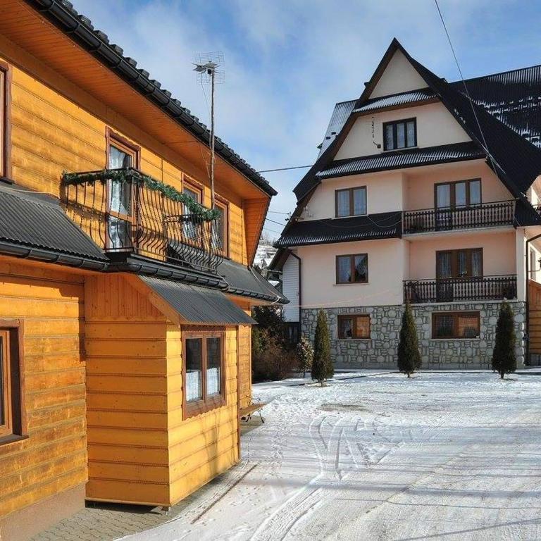 a couple of buildings with snow on the ground at U Janiny in Czarna Góra