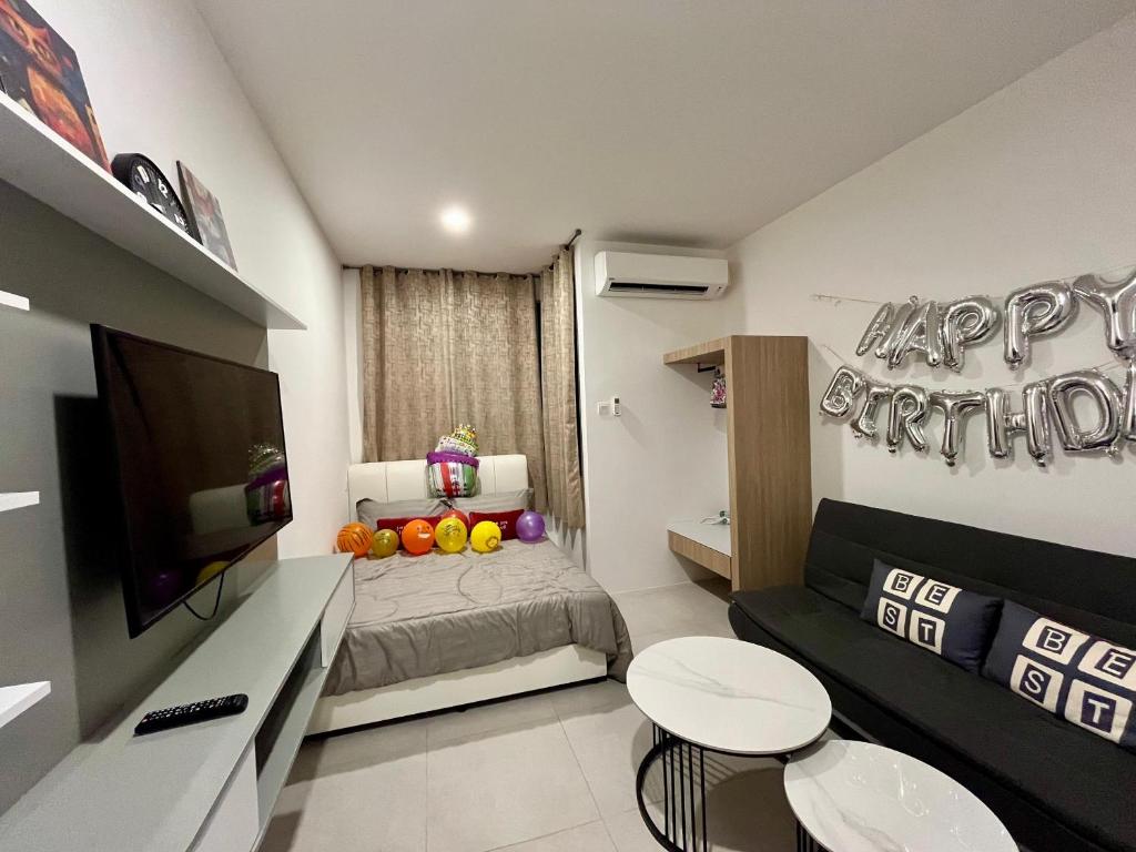 a small living room with a couch and a television at Studio at dMillenia Residences in Kota Samarahan