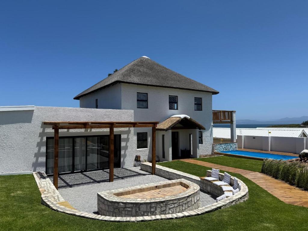 a house with a backyard with a swimming pool at Old Harbour Place in Gansbaai