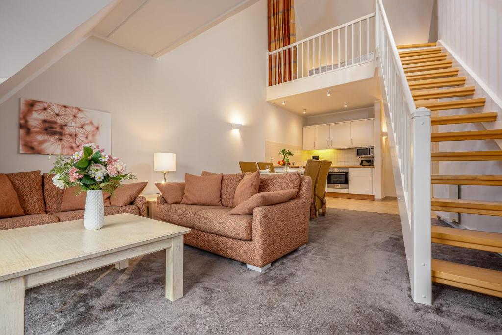 a living room with two couches and a staircase at Strandnest in Dierhagen