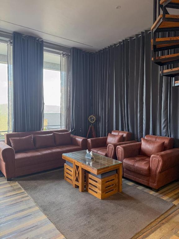 a living room with two couches and a coffee table at Saffron 2 Bedroom Duplex Villa in Mukteshwar