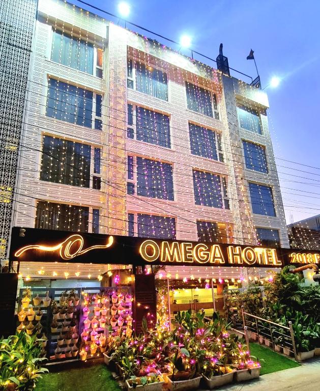 a large building with flowers in front of it at Hotel Omega - Gurgaon Central, Sec 45 in Gurgaon