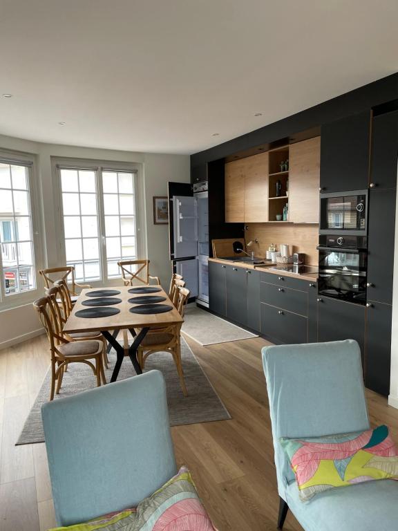 a kitchen and dining room with a table and chairs at Merville Centre in La Roque-Baignard