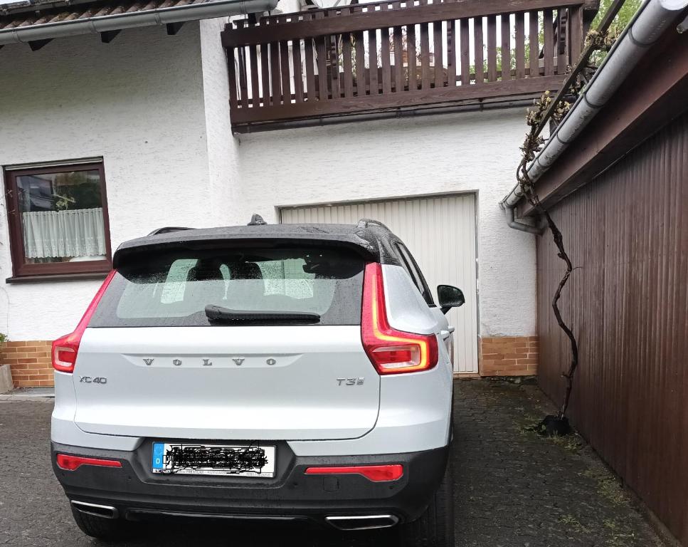 a white car parked in front of a house at Erholsame Westerwälder Ferienwohnung in Weitefeld