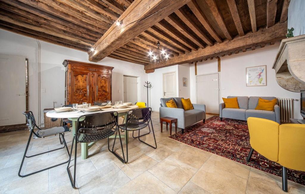 a living room with a table and chairs and a couch at Le Logis Tournusien in Tournus