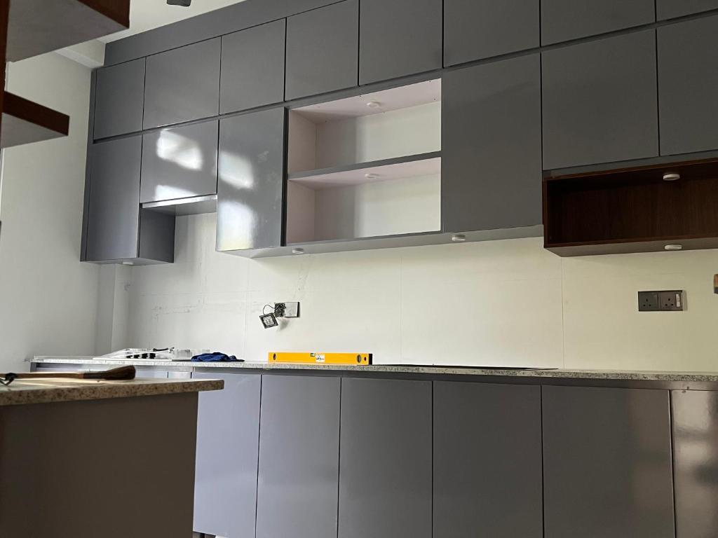 a kitchen with gray cabinets and stainless steel appliances at SSK Rent Villas in Matara