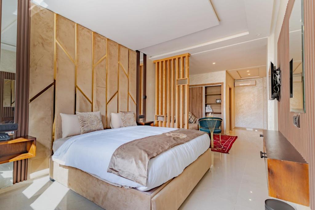 a bedroom with a large bed with a wooden headboard at Hotel Rhali Dakhla in Dakhla