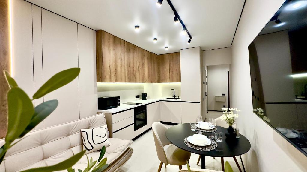 a kitchen and dining room with a table and chairs at City Park Irpin - four in Irpin