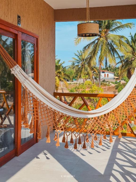 a hammock on a balcony with a view of the ocean at Icaraizinho House in Icaraí