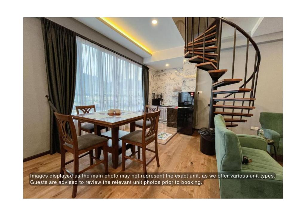 a dining room with a table and a spiral staircase at Hotel Lavie at Centrum in Brinchang