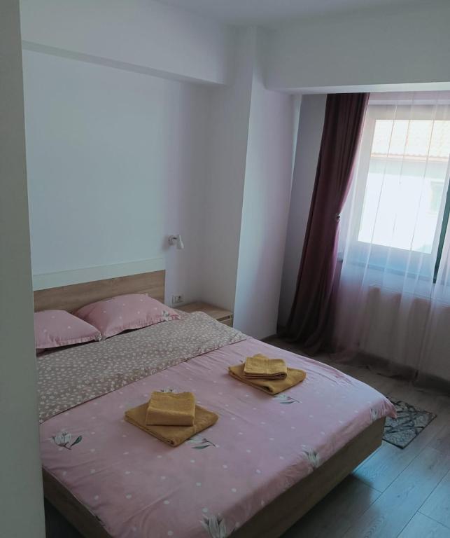 a bedroom with a bed with two towels on it at Central Apartment Bacău in Bacău