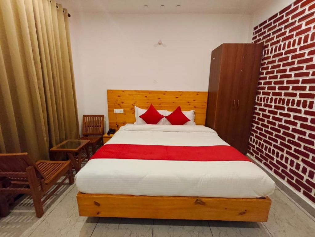 a bedroom with a large bed with red pillows at Mukteshwar Valley Resort in Mukteshwar