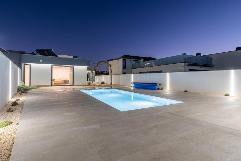 a swimming pool in the backyard of a house at Dune House - Villa With Private Dune and Sea View in Viana do Castelo
