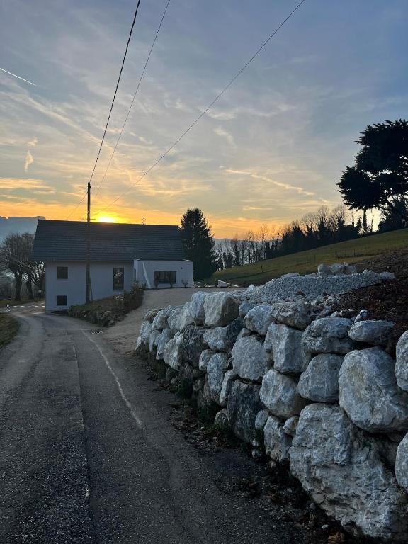 L'Orée du Peney في Saint-Jean-dʼArvey: جدار حجري أمام منزل به مبنى