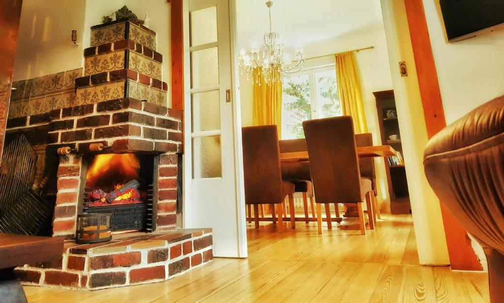 ein Wohnzimmer mit einem Kamin und einem Esstisch in der Unterkunft Ferienhaus Sanssouci in Stahnsdorf