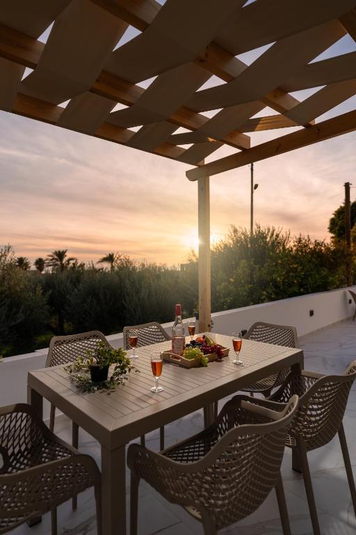 a table with glasses of wine on a patio at Alea Villa in Ierapetra