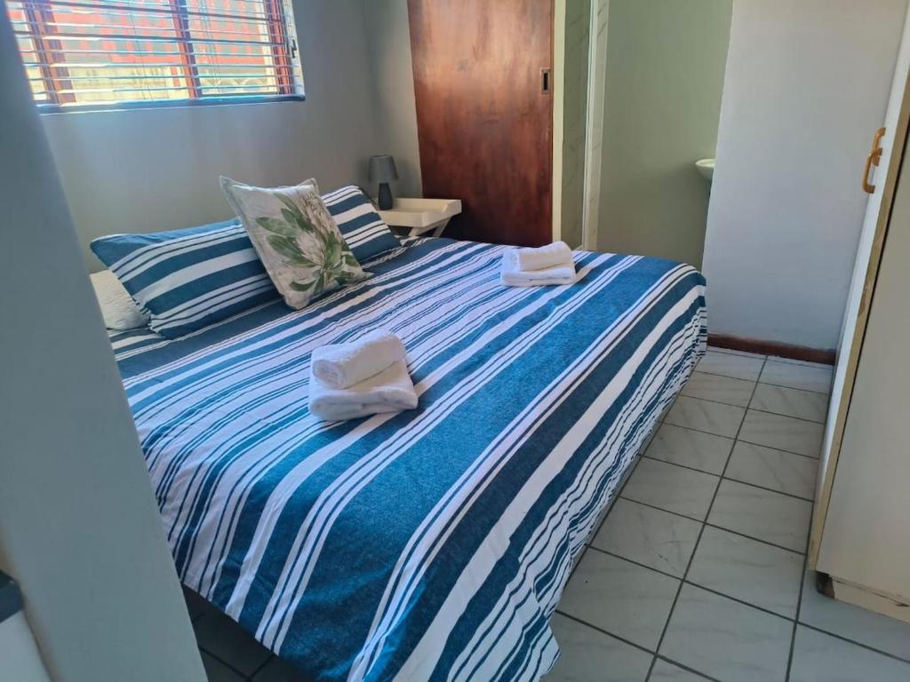 a bedroom with a bed with towels on it at LaBoezma Accommodation in Oudtshoorn