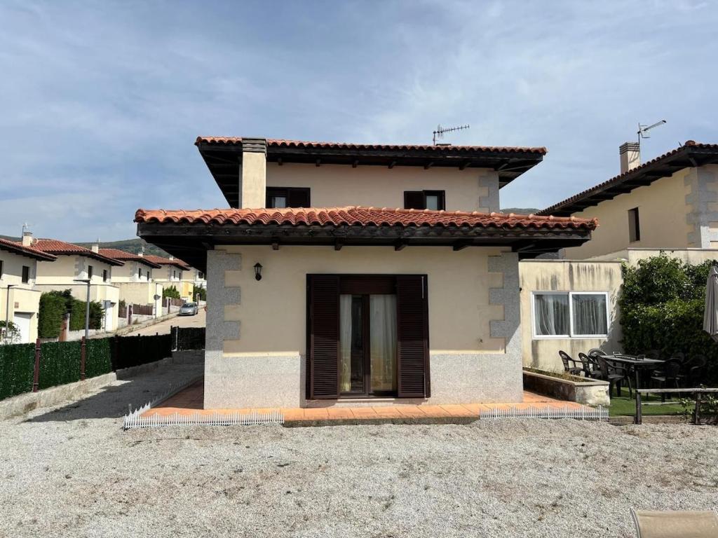 a small white house with a roof at Casa Rural Aires de Mondalindo in Bustarviejo