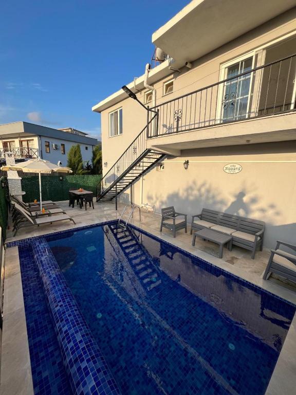 a swimming pool in front of a house at Villa Nazard in Kaş