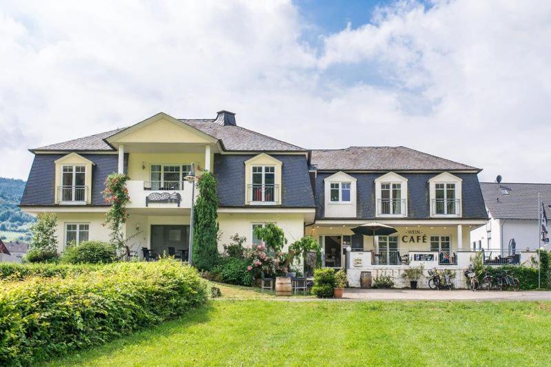 a large house with a lawn in front of it at Doppelzimmer mit direktem Moselblick in Briedern