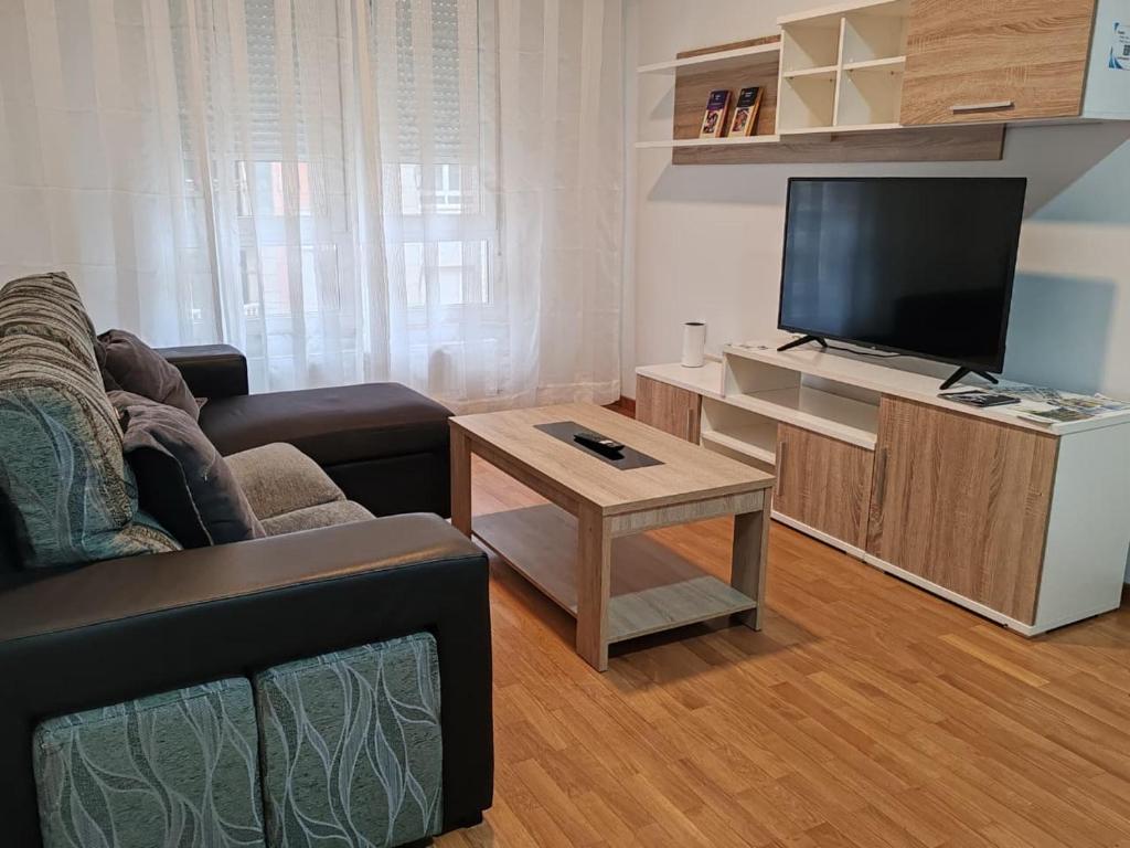 a living room with a couch and a flat screen tv at Os Garitos in Ribadeo