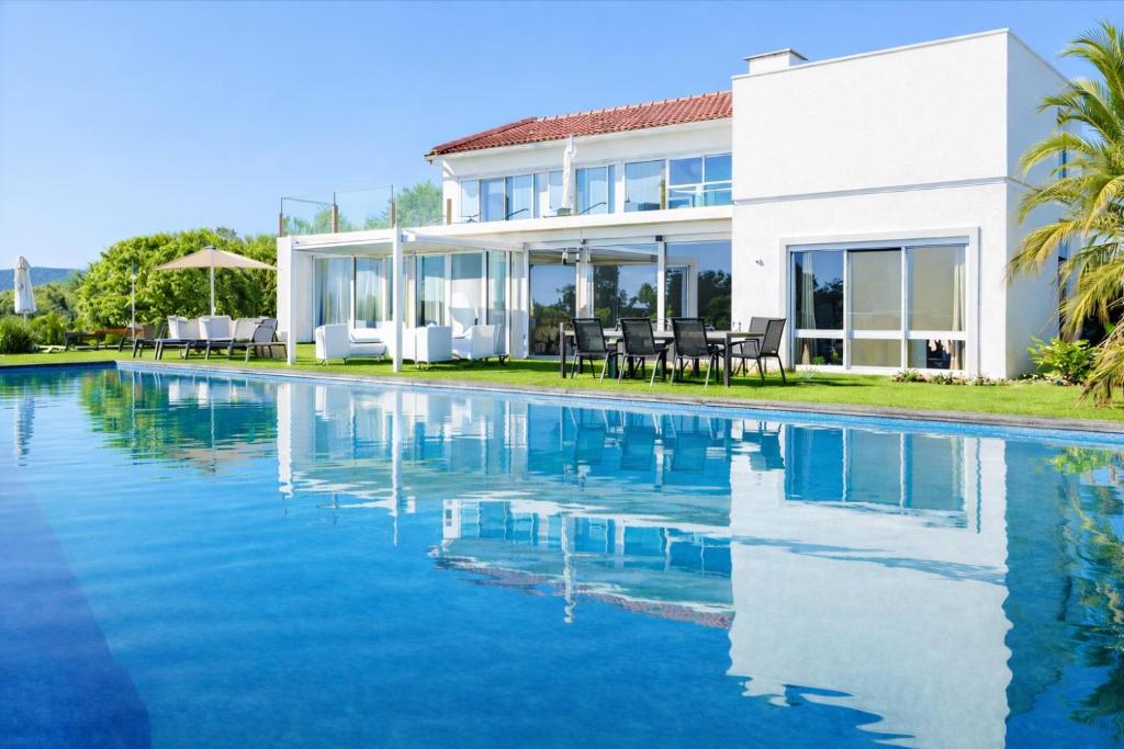 a house with a swimming pool in front of it at CASA DO LAGO, Infinity Pool, Mountains & Sea view in Estói