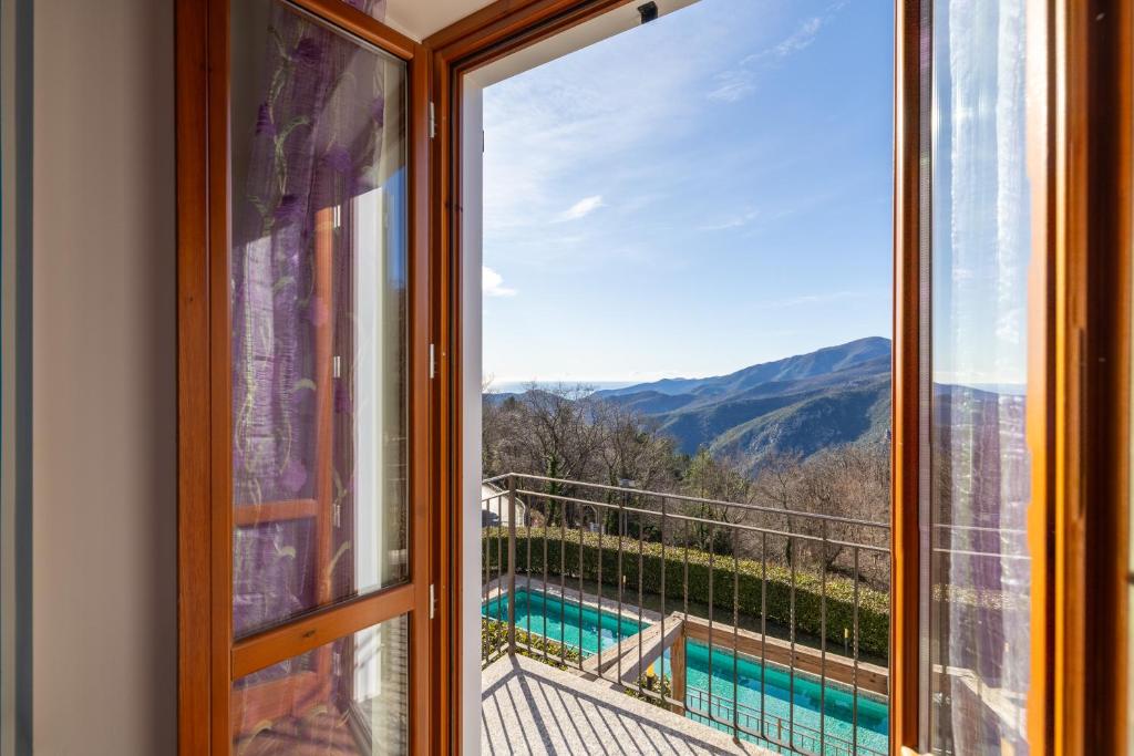 a window with a view of a swimming pool at Hostdomus - Villa Bea free garage and pool in Magliolo